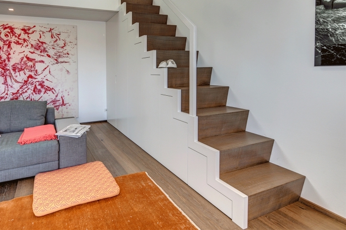 déco avec aménagement sous escalier, salon ouvert aux murs blancs avec grande peinture abstraite de couleurs rouge et blanc