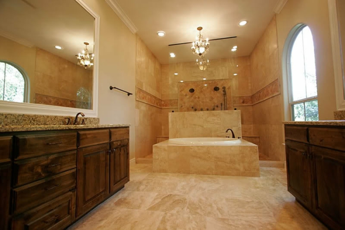 sol travertine salle de bain beige, meubles en bois, grandes fenêtres arquées