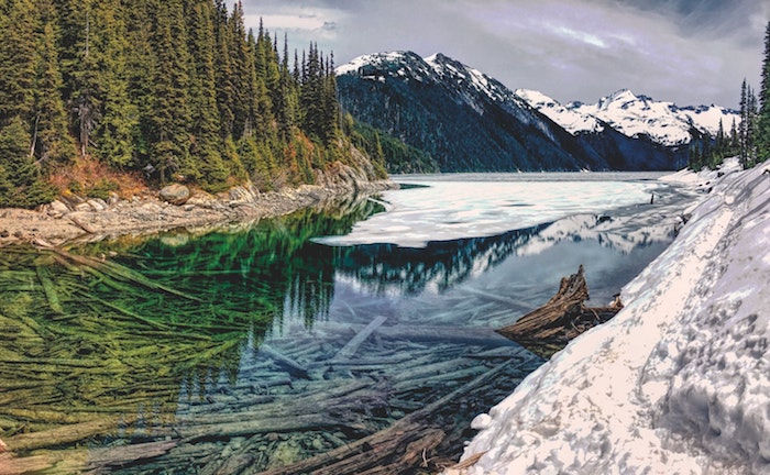 paysage d hiver whistler en neige, une rivière aux eaux limpides, forêts et montagnes autour, vue spectaculaire, que visiter au Canada