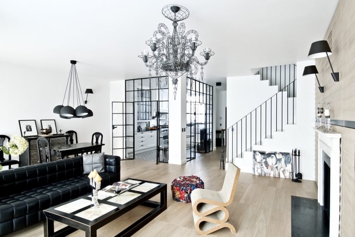cuisine ouverte avec verrière, déco moderne en blanc et noir avec meubles noirs et revêtement mur et sol en bois clair