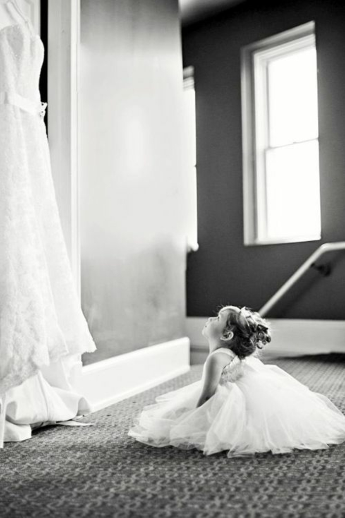Belle fille en robe demoiselle d’honneur robe petite fille d’honneur photo mignonne fille qui regarde la robe de mariée