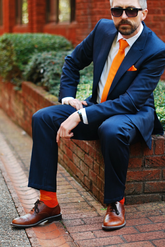 costume bleu roi et chaussettes oranges, aspect professionnel, chemise blanche, montre en noir, look business