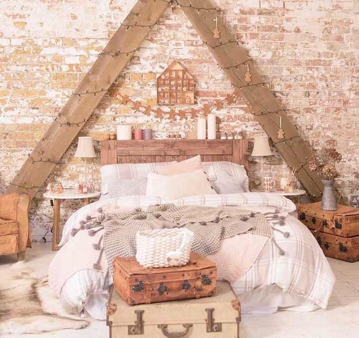 deco chambre vintage cocooning, triangle de planches de bois décorées de guirlande de noel, tete de lit originale en bois avec bougies, linge de lit gris et blanc, bout de lit en malles vintage