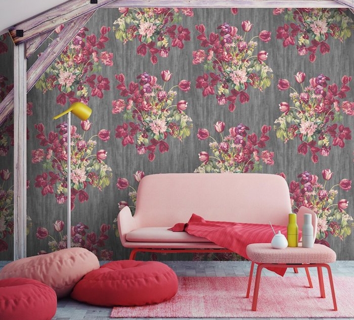 exemple associer une couleur au gris, murs gris foncé à motifs floraux, canapé rose, table rose avec pieds rouges, pouf rose et rouge, tapis rose