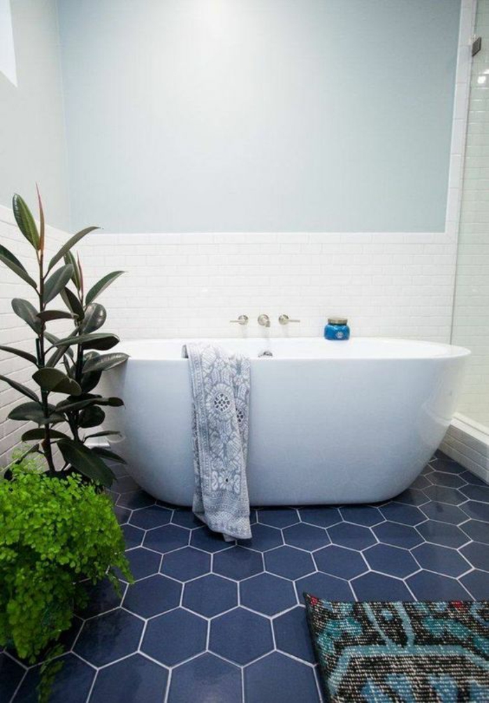 carrelage bleu royal hexagonal, salle de bain 6m2, petite baignoire ovale, mur bicolore, en bleu pastel et en faïence blanche, tapis multicolore en bleu turquoise, noir et rouge