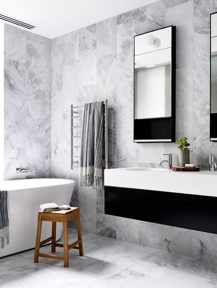 modèle de salle de bain en blanc et noir avec carrelage mural et sol à design marbre gris et blanc, meubles sous lavabo en blanc et noir mate