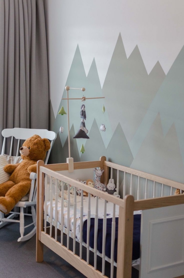 idée déco chambre bébé aux murs de couleurs neutres avec lit à barreaux de bois et rideaux longs gris clair