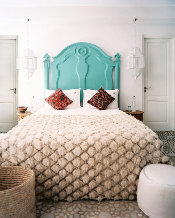chambre à coucher d'ambiance marocaine où on mise sur les textiles typiques et la tete de lit bois turquoise