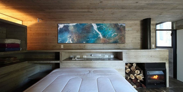 décoration chambre à coucher, poêle rustique et range bûches, tableau abstrait