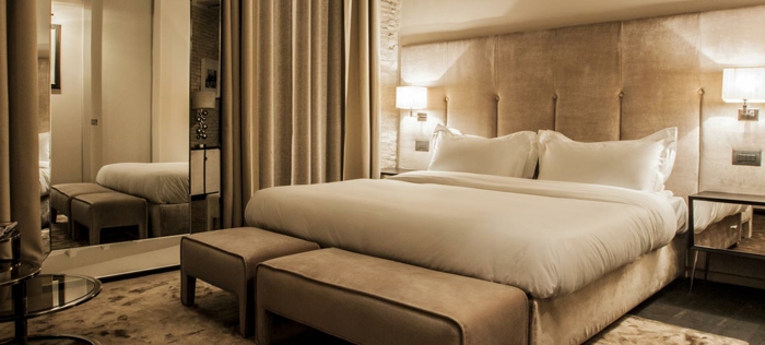 décoration de couleur crème dans une chambre romantique, tête de lit moelleuse, tapis beige, banquette de lit beige