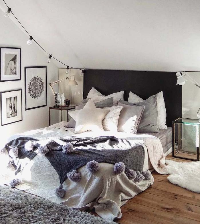 idee deco tete de lit noire avec guirlande d ampoules electriques, linge de lit gris et blanc, parquet en bois, tapis gris, coussins décoratifs