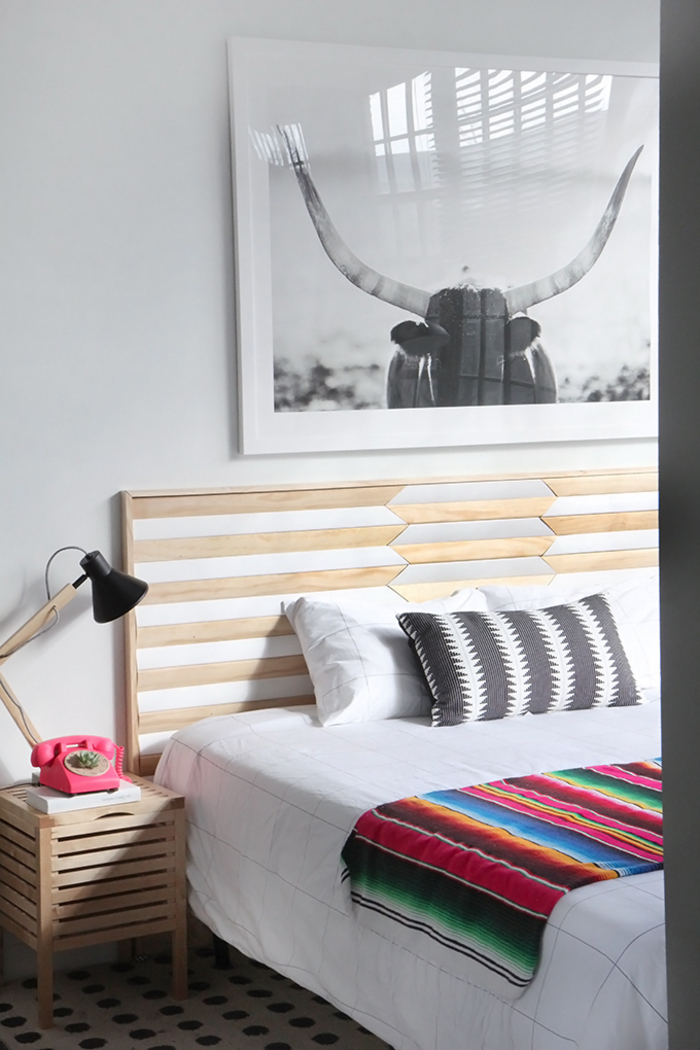 les motifs géométriques sur le textile et la tete de lit bois créent une ambiance moderne et chic dans la chambre à coucher