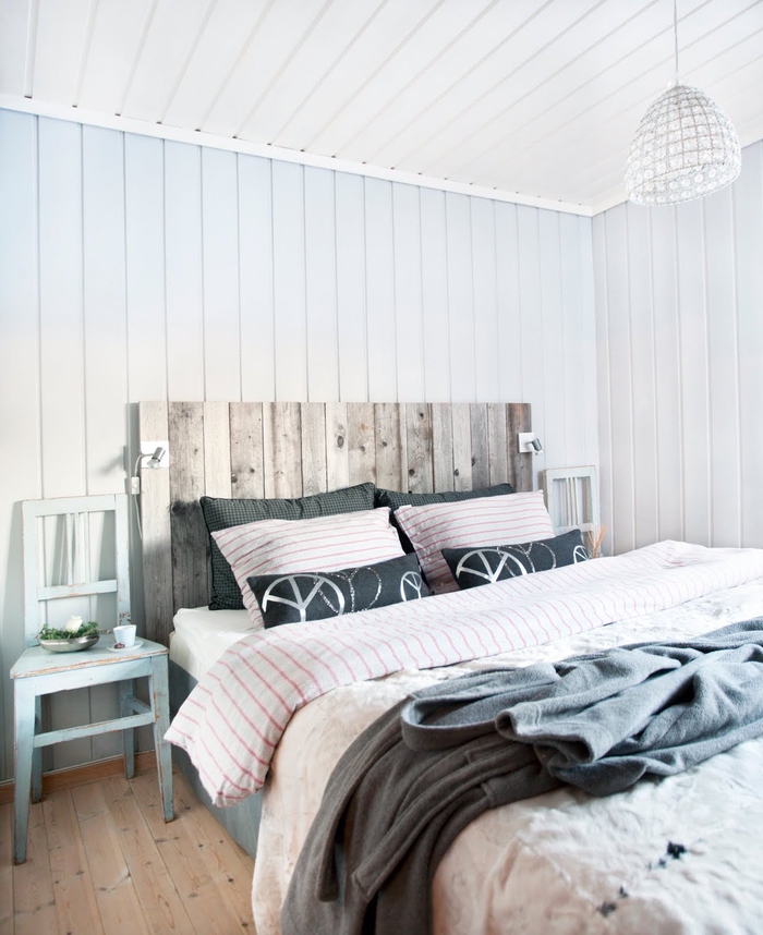 chambre à coucher d'ambiance rustique sereine revêtue de lambris qui contraste avec la tete de lit bois brut