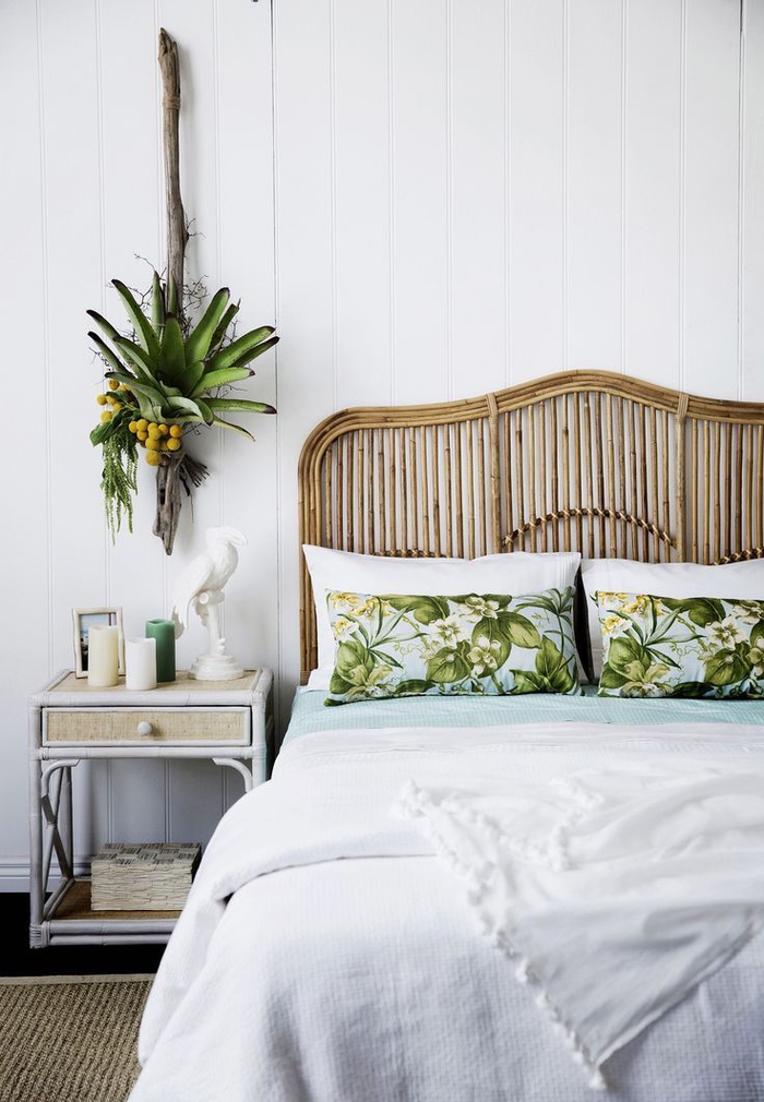 une chambre à coucher de style colonial avec une déco tropicale aux imprimés motif jungle et une tete de lit en bambou