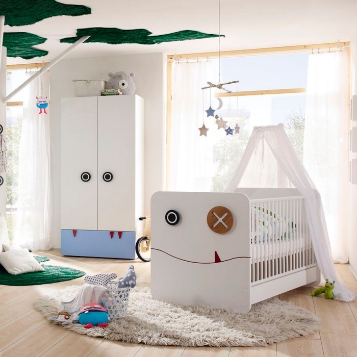 chambre bébé garçon au plafond blanc avec décoration verte et plancher de bois clair couvert de tapis moelleux blanc