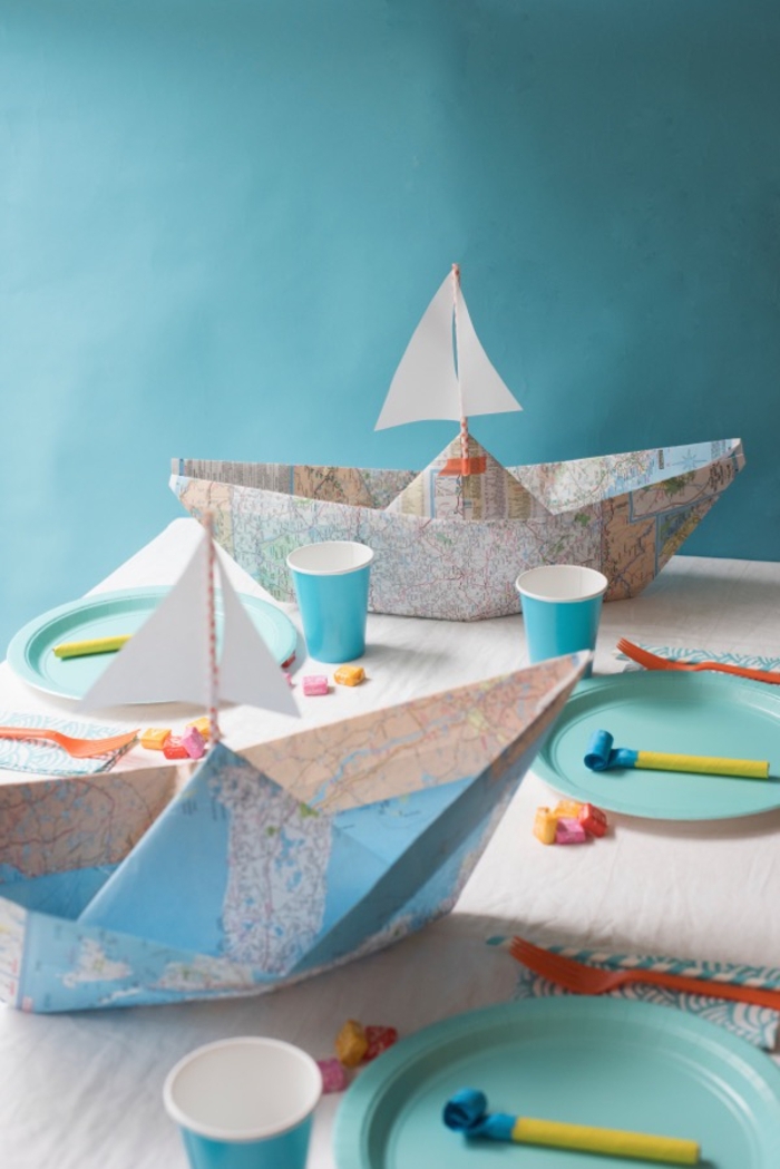 une déco de table qui fait voyager les invités avec sa déco origami en bateaux réalisés avec des cartes routières