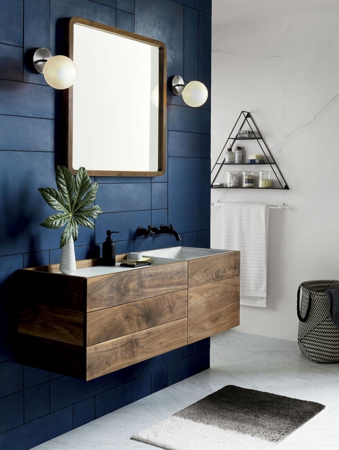 déco de la salle de bain moderne avec peinture murale en bleu foncé et blanc, carrelage à design marbre blanc, étagère en fer et forme triangulaire