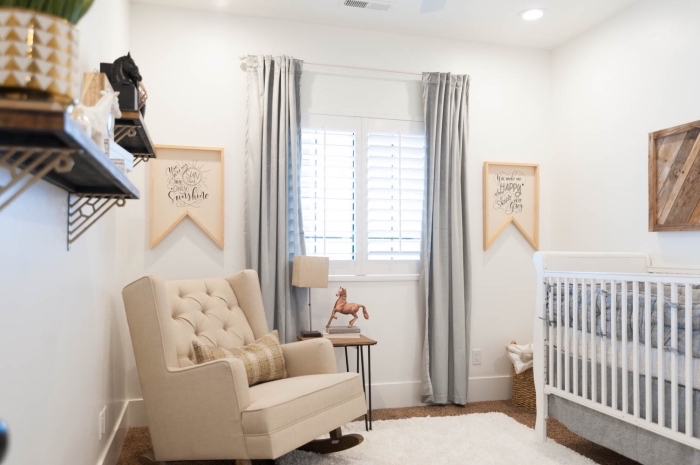 comment décorer la chambre bébé mixte aux murs blancs avec meubles de bois, modèle de grand fauteuil beige devant la fenêtre habillée aux rideaux longs gris