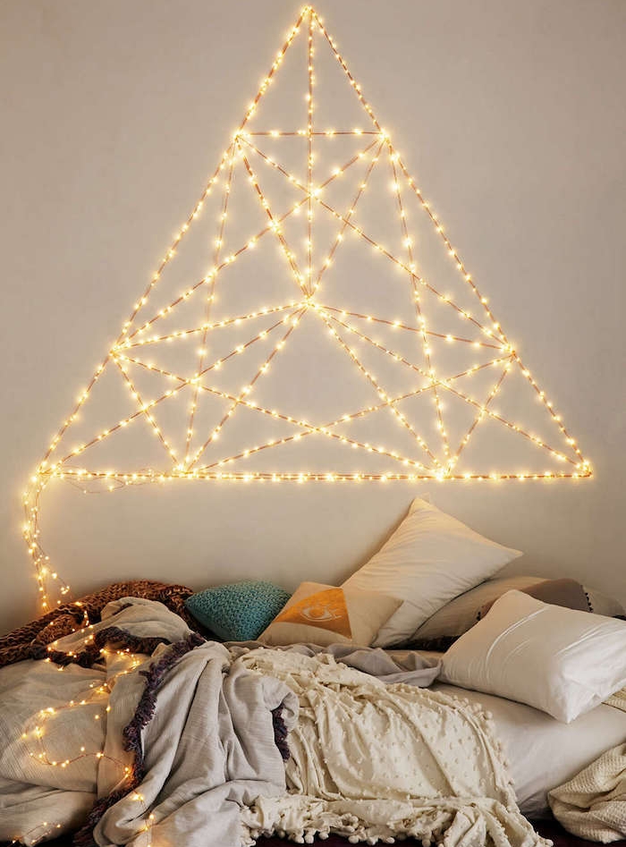 tete de lit en guirlandes lumineuses en triangle sur le mur, coussins colorés et oreillers, linge de lit gris et blanc