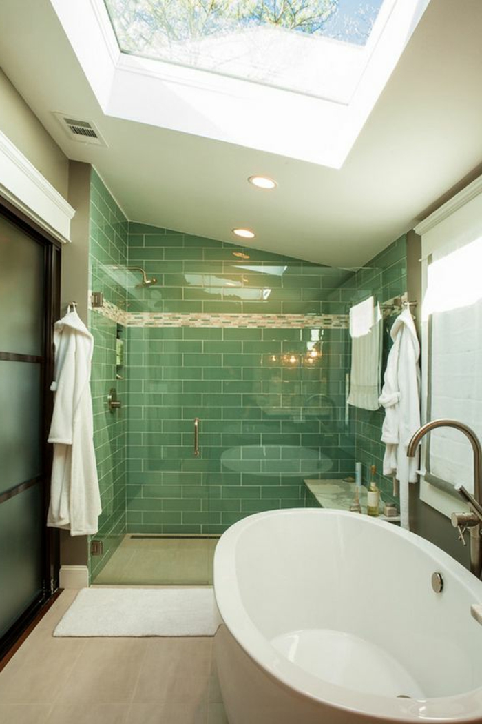 carrelage métro vert dans la cabine de douche, baignoire ovale, puits de lumière