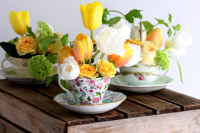 des tasses de thé style shabby chic décorées à motifs floraux avec des fleurs prinatières à l intérieur, deco centre de table floral
