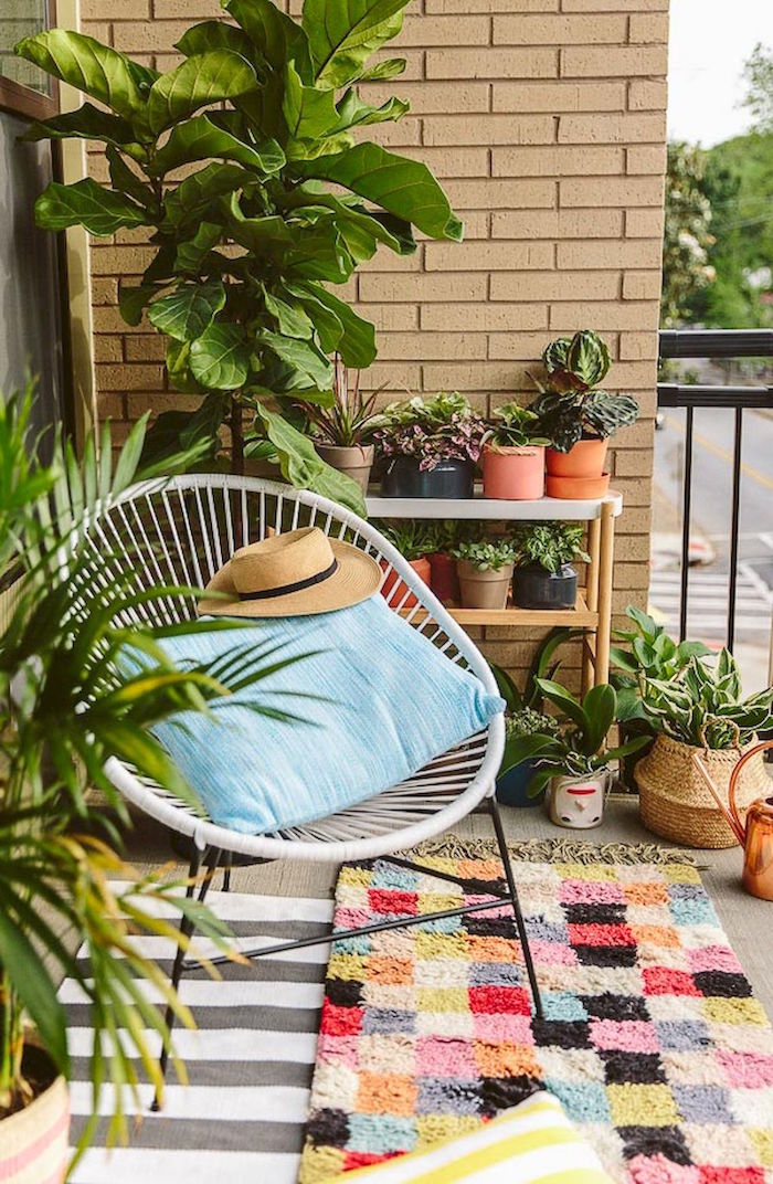 photo de balcon décoré avec plantes et jardiniere, rocking chair blanc pour terrasse, tapis coloré balcons