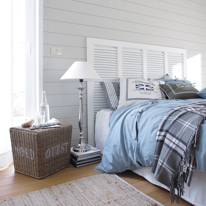 ambiance sereine avec un lambris blanc et une tete de lit bois récup dans une chambre à coucher de style bord de mer 