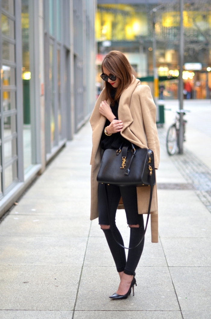 modèle de sac à main de cuir noir et or, femme stylée en pantalon troué noir et chaussures noires à talons hautes