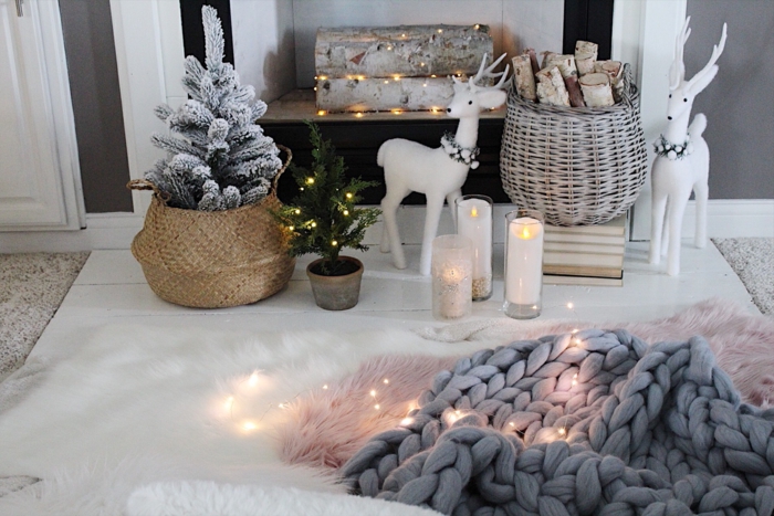 déco de Noel miraculeuse, plaid tricoté, bougies allumées, panier tressé avec petit sapin, bûches décoratives