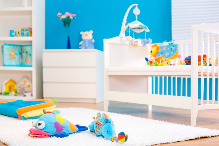comment décorer la chambre bébé fille ou garçon en blanc et bleu, meubles de bois blanc sur un parquet de bois clair avec tapis moelleux