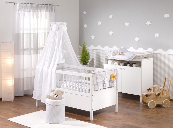 modèle de chambre bebe complete aux murs gris et blanc avec plancher de bois foncé et un lit à barreaux avec baldaquin blanc
