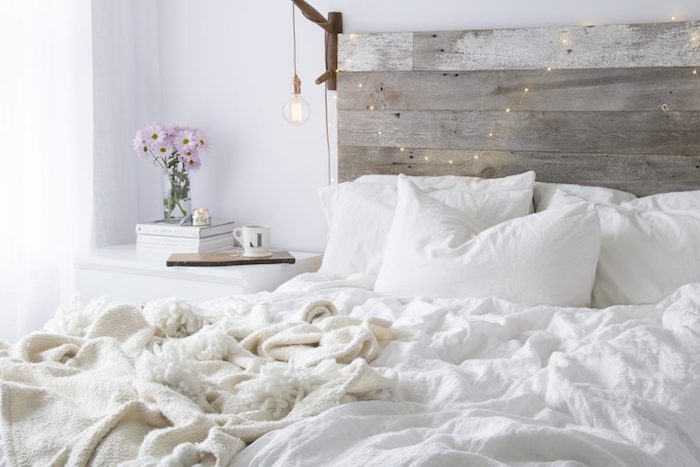 exemple pour fabriquer une tete de lit en bois avec suspension ampoule et guirlande de noel, linge de lit blanc