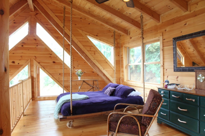 lit suspendu dans une chambre style attique, placard bleu, fauteuil marron
