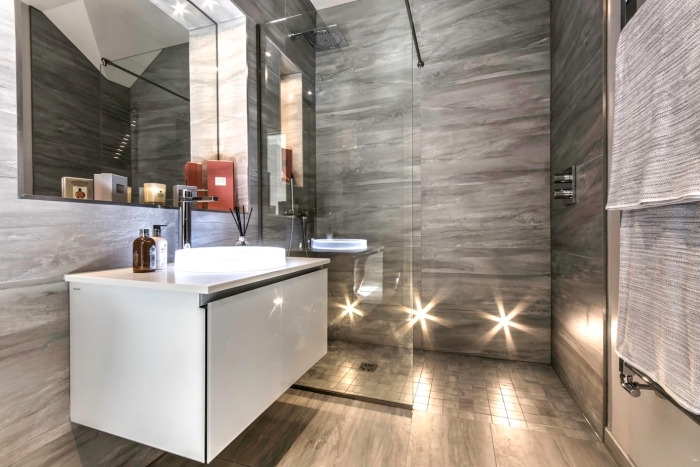 modèle de cabine de douche avec paroi de verre et carrelage gris, déco de petite salle de bain en gris avec armoire blanche