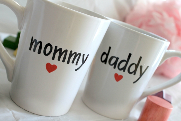 annoncer grossesse, deux tasses à café blanches avec un texte noir, maman et papa