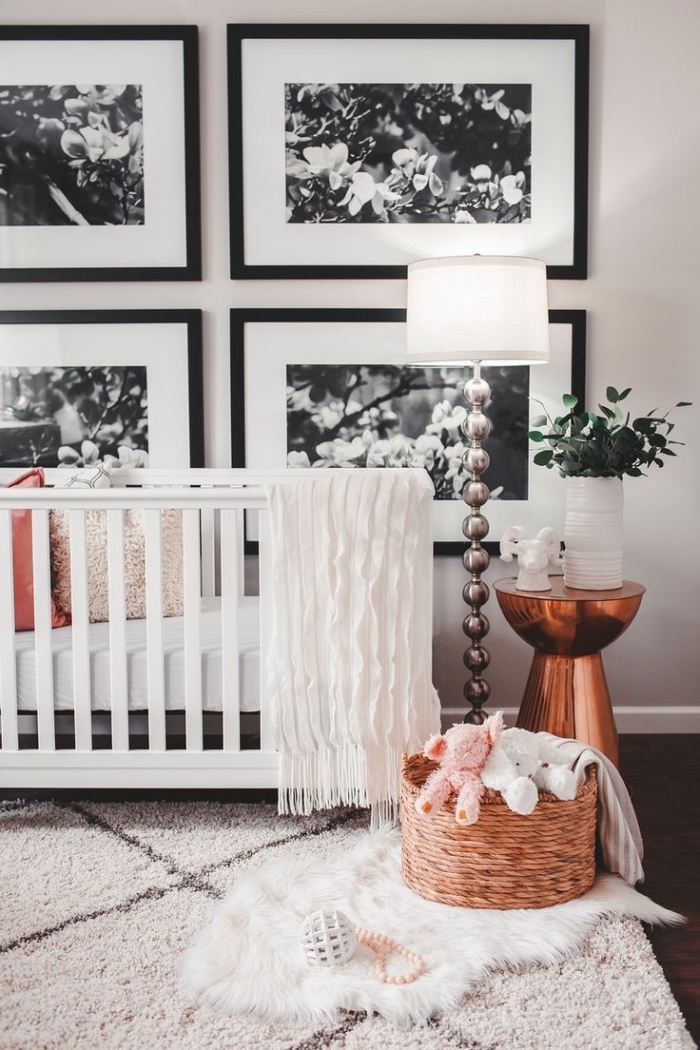exemple d'une chambre bébé mixte aux murs blancs et plancher de bois foncé avec tapis moelleux et table de chevet cuivrée