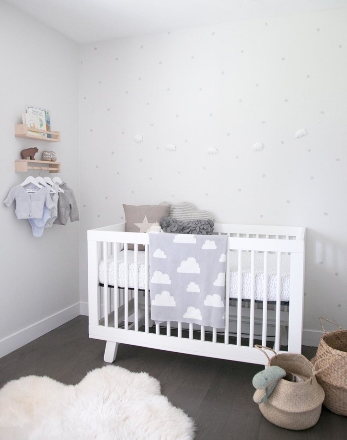 style minimaliste dans la chambre bébé avec lit blanc et tapis moelleux, panier en fibre végétal pour jouets de bébé