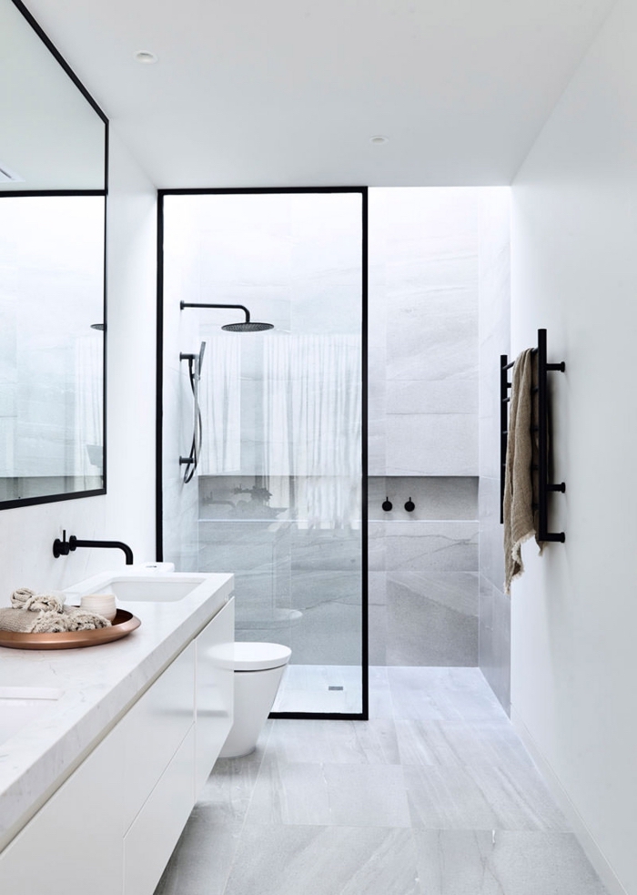salle de bain blanche avec carrelage à design marbre blanc et cabine de douche à paroi verre et noir mate