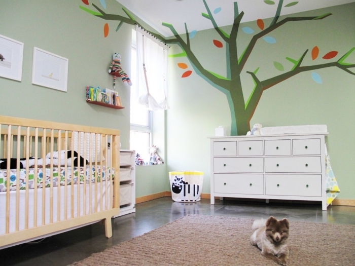 exemple de chambre bebe complete avec lit à barreaux de bois clair et armoire blanche sur plancher noir couvert de tapis beige
