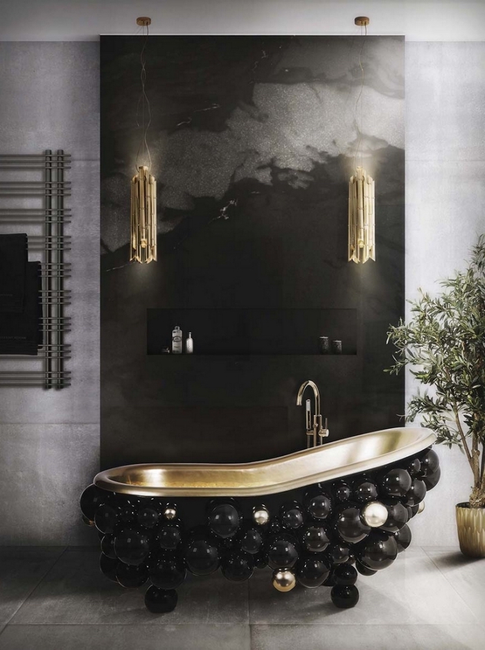 modele salle de bain luxueuse et élégante en couleurs foncées avec revêtement de pan de mur en noir marbre et appliques cuivrées