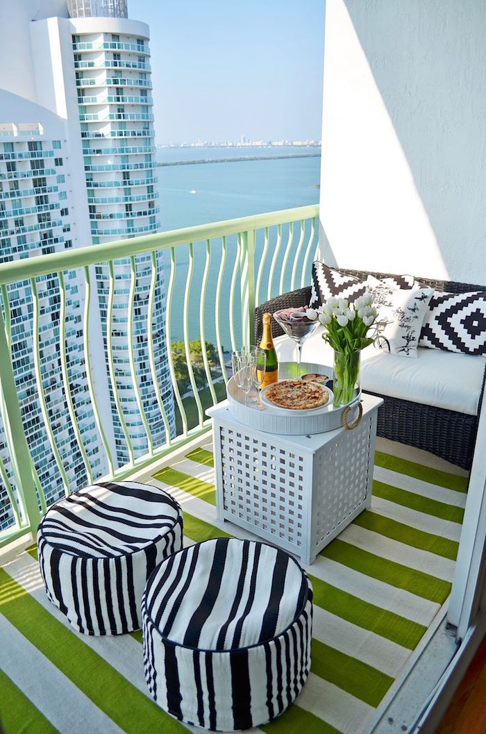petit balcon en hauteur avec vue sur mer, mini terrasse appartement avec canapé et pouf noir et blanc