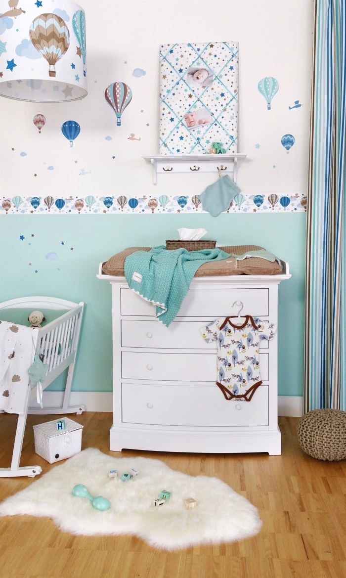 peinture murale en blanc et turquoise avec stickers autocollants, idée déco chambre bébé en couleurs neutres et pastel avec tapis moelleux blanc