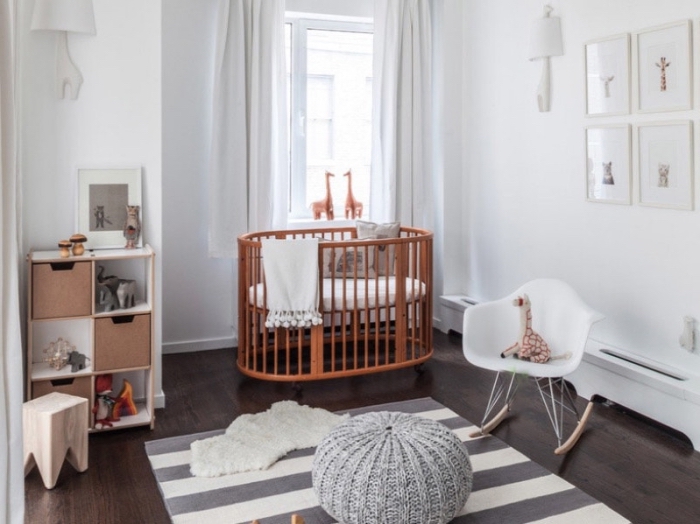 décoration minimaliste dans la chambre bebe complete avec lit rond et rangement de bois verticale, tapis rayé en blanc et gris