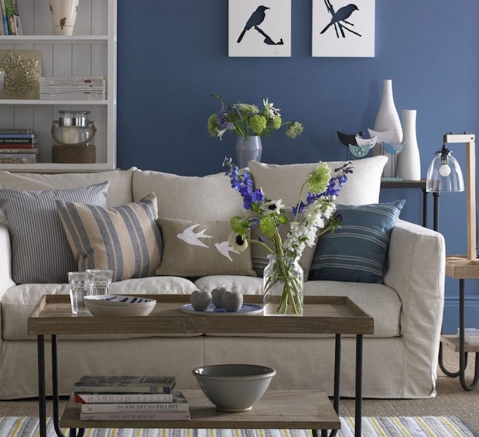 idée quelle couleur avec le gris, canapé gris clair, coussins beige, gris et bleu, table basse en bois et metal mur décoré de peinture bleu nuit