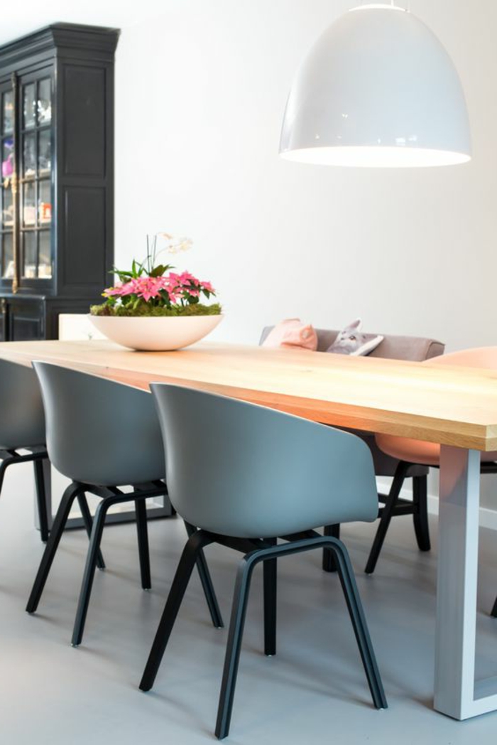 renover sa cuisine, trois fauteuils en plastique bleu, sol avec carrelage brillant blanc, table rectangulaire en bois clair avec des pieds blancs, armoire de cuisine en style ancien en noir