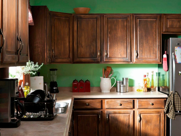 meubles armoires de cuisine en marron, style vintage, murs en vert herbe, grand frigo couleur argent, électroménagers et machine a café