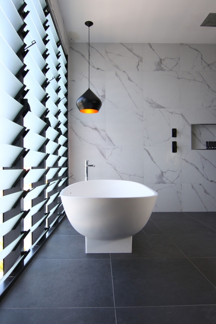 amenagement salle de bain moderne aux murs à carrelage marbre blanc et plancher à carrelage gris anthracite