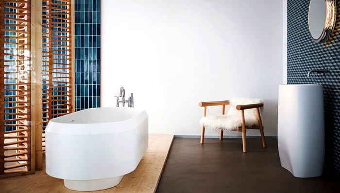 meuble salle de bain bois avec paroi séparant et chaise de bois couverte de housse en faux fur blanche, miroir oval à design métallique argenté