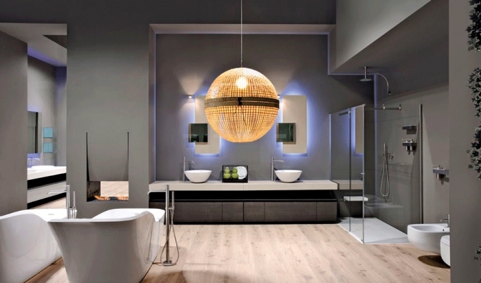 éclairage moderne pour la salle de bain aux murs gris et plancher de bois clair, meubles et équipement de salle de bain en blanc