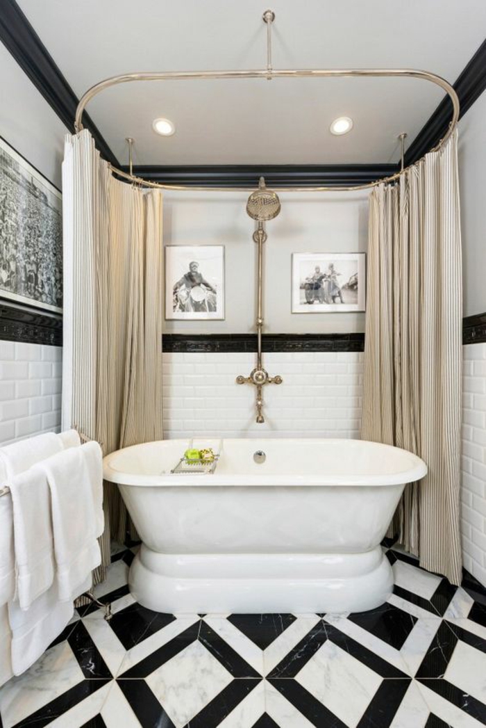 agencement salle de bain, salle de bain 5m2, petite baignoire ovale blanche, avec des rideaux en ivoire sur du métal couleur argent, carrelage du sol en noir et blanc, avec de motifs grands losanges, trois tableaux aux murs avec des lithographies en noir et blanc